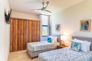 普拉亚卡门Entire House- 3BR with Private Roof Top Deck的有两张床和一扇窗户的卧室 更多48张照片