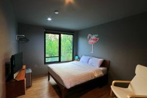 a bedroom with a bed with a flamingo on the wall at LAN LAY Resort (ลานเล รีสอร์ท) in Ban Mai Rut