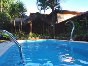 a swimming pool in a backyard with a house at Pousada da Terra Paraty in Paraty