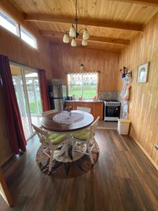 a kitchen with a table and chairs in a room at Cabañas Teresa Frutillar in Frutillar +18 photos