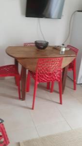 einem Holztisch mit einem roten Stuhl und einem Tisch mit einem TV in der Unterkunft T2 Coquet agréable résidence Marina di bravone in Linguizzetta