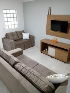 a living room with a couch and a flat screen tv at Casa Beira Rio Xingó in Canindé de São Francisco