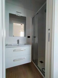un bagno bianco con lavandino e doccia di VENTO DI BOLINA a Giovinazzo