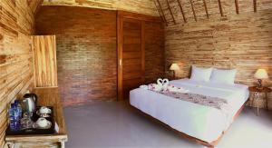 a bedroom with a large white bed in a room at Maruti Beach Club in Nusa Penida