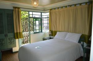 a bedroom with a white bed and a large window at Collacocha B&B in Lima