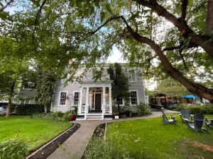 uma casa branca com um alpendre e um relvado em McCully House Inn em Jacksonville