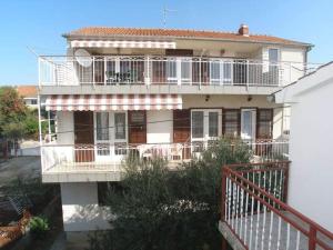 a large house with a balcony on the side of it at Apartments Celine & Fabienne in Brodarica