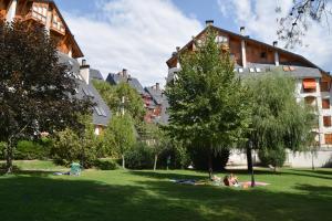 a group of people laying on the grass in a park at Acogedor apartamento con piscina compartida y opción a parking in Jaca