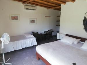 a bedroom with two beds and a table and chairs at Hotel Villa Sirena in Vichayito