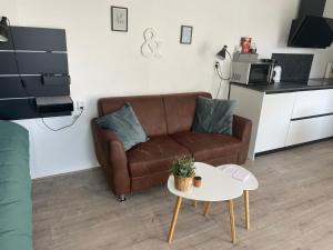 a living room with a couch and a table at Strandhuussie Texel in De Koog