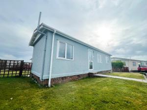 uma casa azul sentada em cima de um quintal em Stowaway St Merryn em Saint Merryn