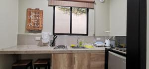 a kitchen with a counter with a sink and a window at Habitación B independiente para parejas o ejecutivos in Manta