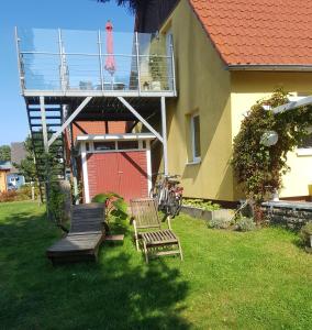 a yard with two chairs and a deck with a balcony at Sina in Pruchten