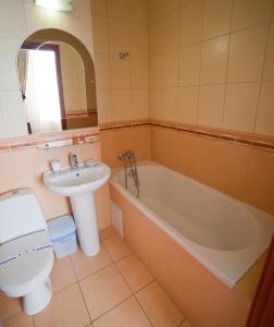 a bathroom with a sink and a tub and a toilet at Hotel Sani in Truskavets