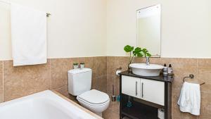 a bathroom with a tub and a toilet and a sink at Point bay in Durban +7 photos