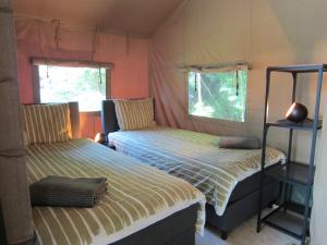 Un pat sau paturi într-o cameră la HderH-GlampingDeVeluwe, privé keuken, sauna, hottub en sanitair, op vakantiepark De IJsvogel met zwembaden en alle faciliteiten