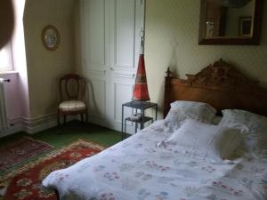 a bedroom with a bed with a red lamp and a chair at Le Kino Panorama in Vic-sur-Cère