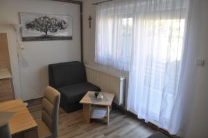 a living room with a chair and a window at Apartmani Ana Vukovar in Vukovar