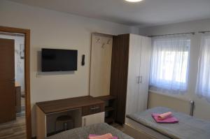 a small room with a bed and a television at Apartmani Ana Vukovar in Vukovar