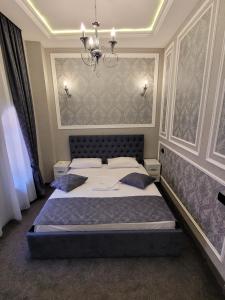 a bedroom with a bed and a chandelier at Hotel Roma & Tours in Yerevan