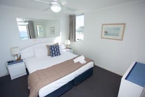 Tempat tidur dalam kamar di Grosvenor Beachfront Apartments Surfers Paradise