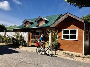 a person riding a bike in front of a house at Ambiance Villa in La Digue