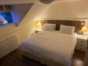 a bedroom with a large white bed with two lamps at The Fleet Inn in Killybegs