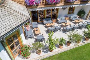 uma vista sobre um pátio com cadeiras e mesas em Hotel Ziegleder em Rottach-Egern