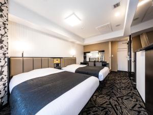 ein Hotelzimmer mit zwei Betten und einem Fernseher in der Unterkunft APA Hotel Kintetsu Nara Ekimae in Nara + 37 Fotos