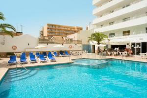 een zwembad met blauwe stoelen en een hotel bij HSM Reina del Mar in El Arenal