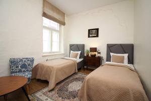 a bedroom with two beds and a table and a window at Tallinn City Apartments - Luxury 3 bedroom, sauna, views in Tallinn