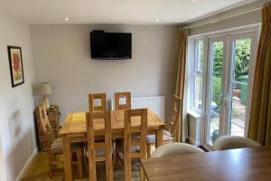 a dining room with a table and a television on the wall at Stylish and modern home in Uppingham, Rutland in Uppingham