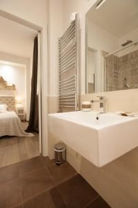 a white bathroom with a sink and a bed at Popolo & Flaminio Rooms in Rome