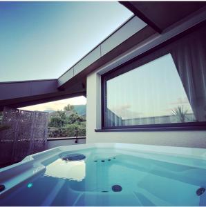 eine Badewanne in einem Zimmer mit einem großen Fenster in der Unterkunft Appius Design Suites B&B - ADULTS ONLY in Appiano sulla Strada del Vino