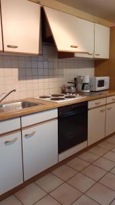 a kitchen with a sink and a stove top oven at FILD - Holiday Apartment in Saint-Vith
