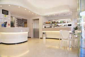 a restaurant with a counter and chairs in a room at Hotel Radar in Rimini