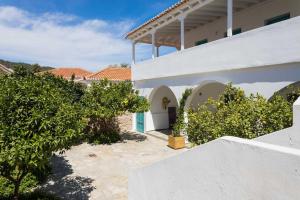 a white house with trees in front of it at Aria Apartments in Spetses