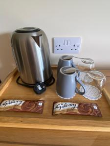 a coffee maker and cups on a wooden table at The Willows in Dalchreichart