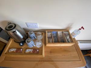 a table with two wooden trays with books and a pitcher at The Willows in Dalchreichart