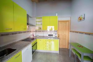 a kitchen with yellow cabinets and a table in it at El Capricho in Villamiel