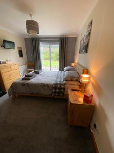a bedroom with a large bed and a window at The Willows in Dalchreichart