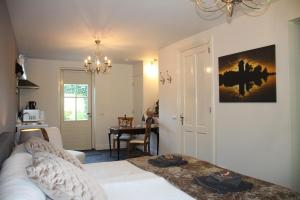 a bedroom with a bed and a dining room at Studio Bed and Breakfast Zaans Moment in Assendelft
