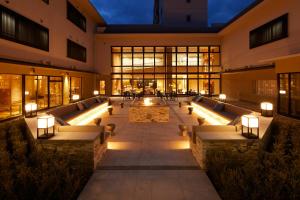 a building with a courtyard with benches and lights at KAMENOI HOTEL Kamogawa in Kamogawa