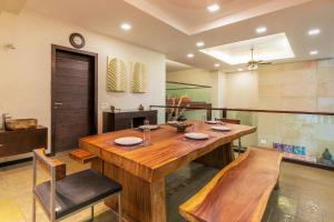 a dining room with a wooden table and chairs at Arihant Villa by StayVista - 5BHK Luxurious Villa with Pvt Pool in Lonavala