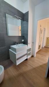 La salle de bains est pourvue d'un lavabo blanc et d'un miroir. dans l'établissement Arco Home, à Arco