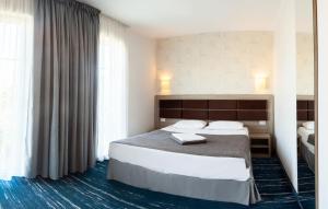 エフォリエ・ノルドにあるHotel Victoriaのベッド2台と大きな窓が備わるホテルルームです。