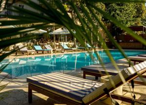 a swimming pool with lounge chairs and a palm tree at Hotel Victoria in Eforie Nord
