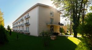 a large white building with a green yard at Hotel Victoria in Eforie Nord
