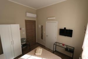 um quarto com uma cama e uma televisão na parede em Le Stanze em Bolonha