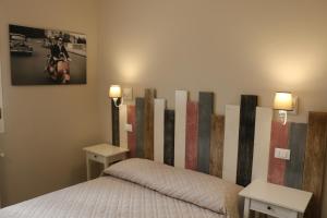 ボローニャにあるLe Stanzeのベッドルーム1室(ベッド1台、テーブル2台、ランプ2つ付)